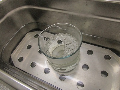 Glass flask in a larger tub of water